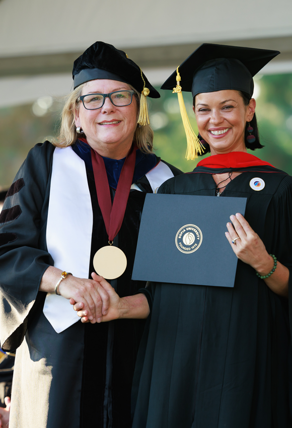 Sofia president shaking hands with graduate on stage